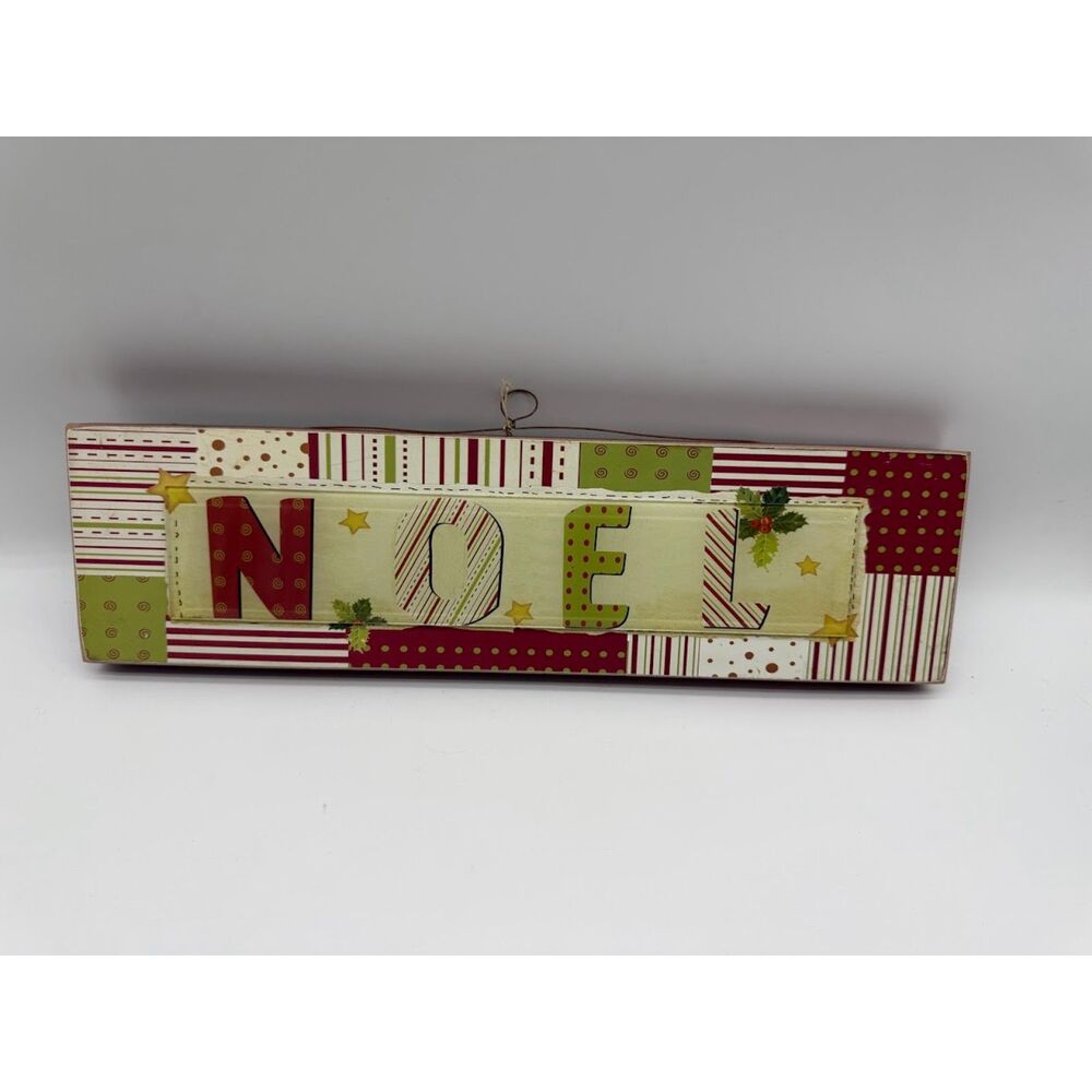Decorative sign  "NOEL" on it, featuring a festive, patchwork-style design